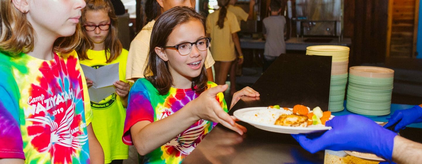Camper receiving dinner at Camp Waziyatah