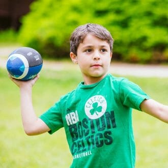 Camper playing football at Camp Waziyatah