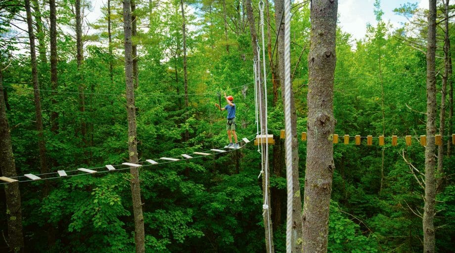 Camper walking across bridge on the high ropes course