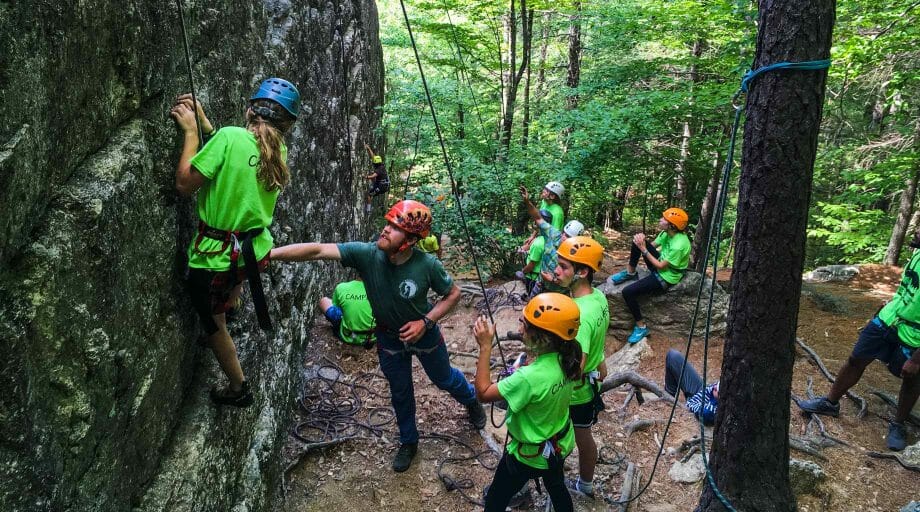 Campers climbing a rock wall on an off-camp trip