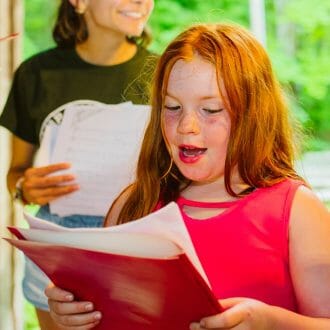 Girls singing for a performance at Wazi