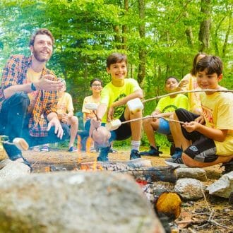 Campers roasting marshmallows at adventure bound at Wazi