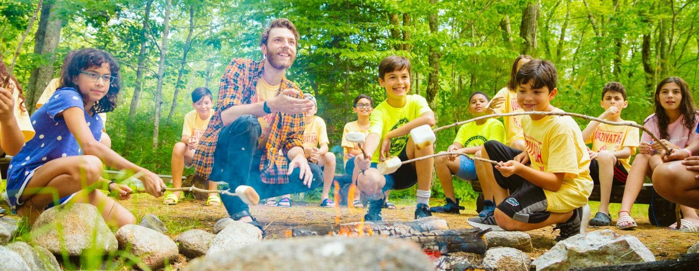 Campers roasting marshmallows at adventure bound