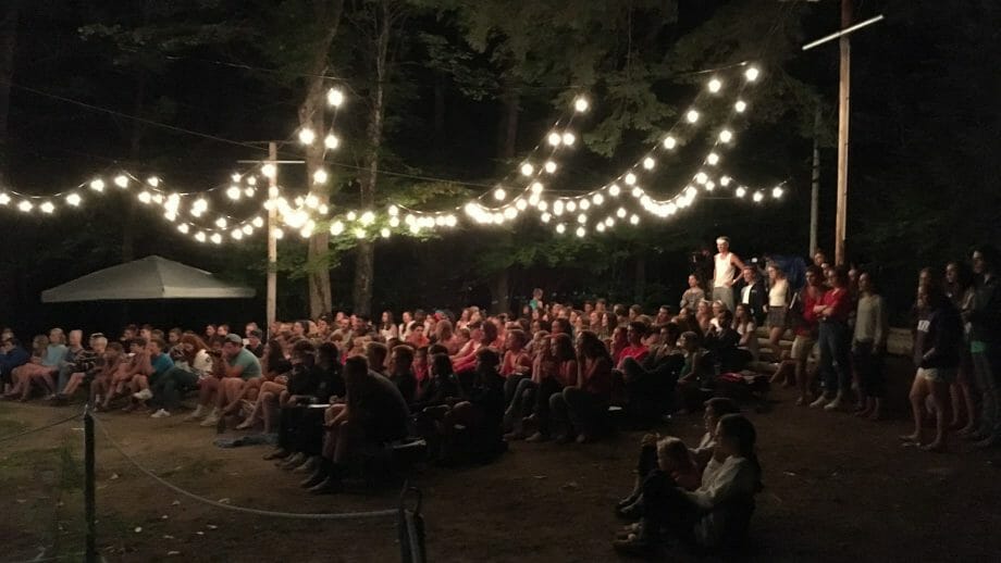 Audience watching an outdoor theater performance at night