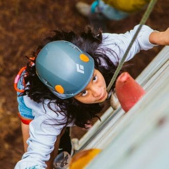 Girl climbing the rock tower at Camp Waziyatah
