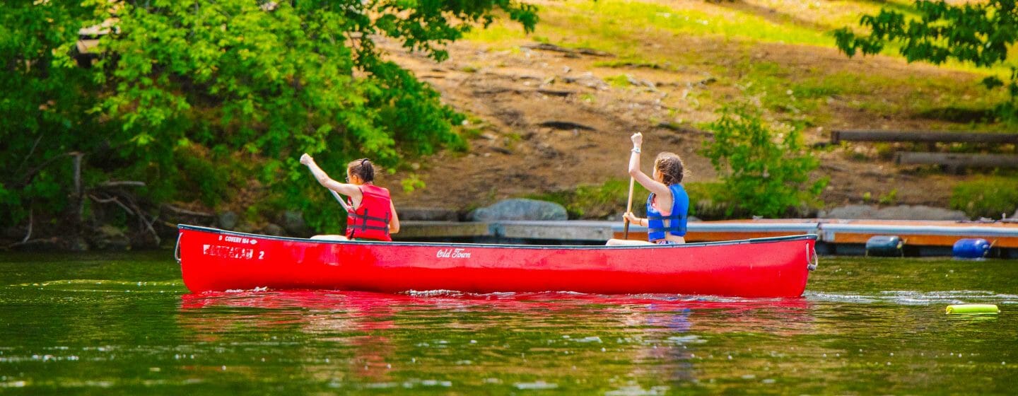 Two girls canoeing on the lake